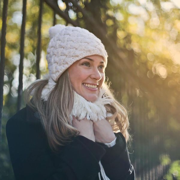 Smiling person stretching outdoors in a park at sunrise.